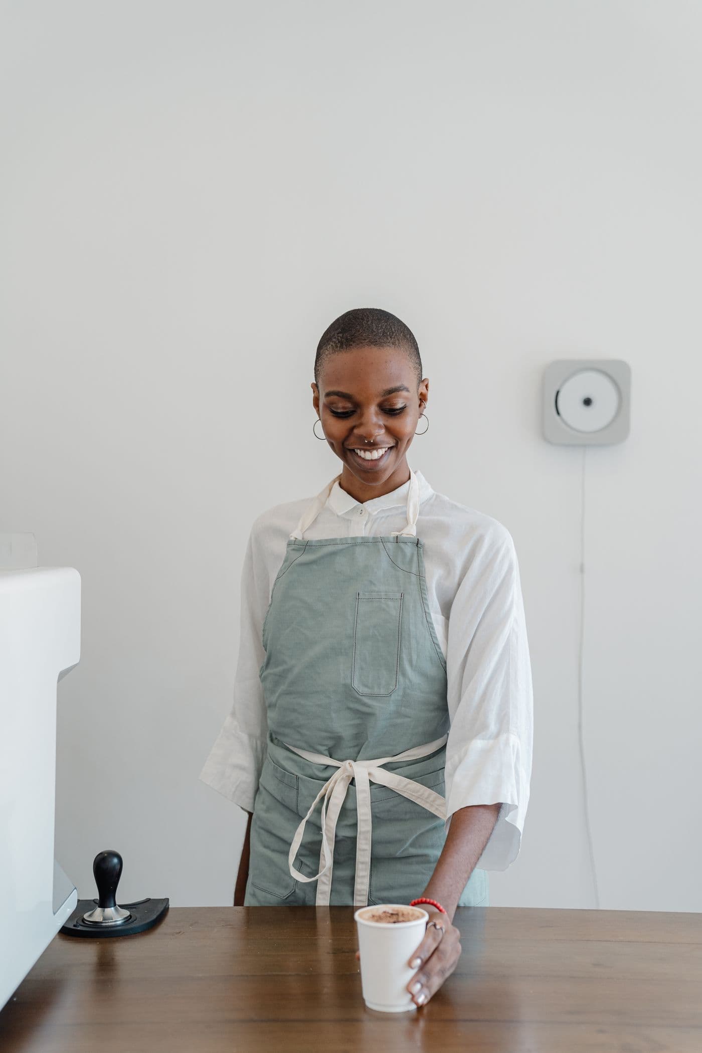 A barista serving a takeaway coffee in a working café
